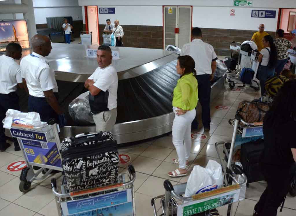 Pasajeros recibiendo equipajes Pasajeros recibiendo equipajes